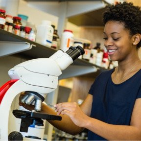 woman looking at microscope